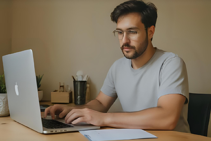 Pessoa iniciando trabalho remoto em casa, com mesa simples, checklist ao lado, sensação de novidade e foco.